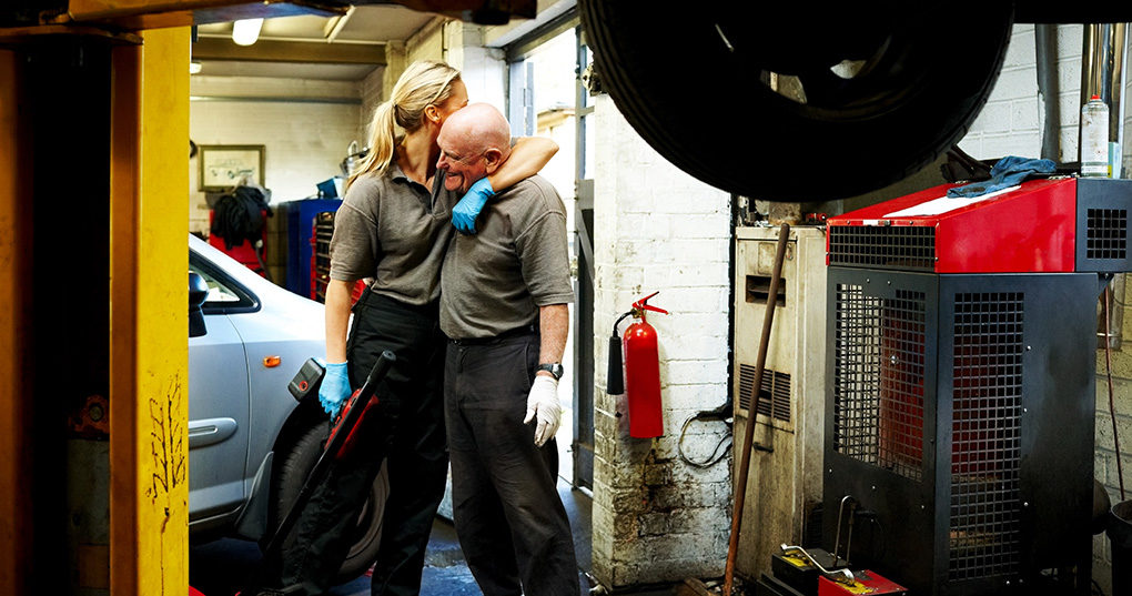 Father and daughter in auto shop.