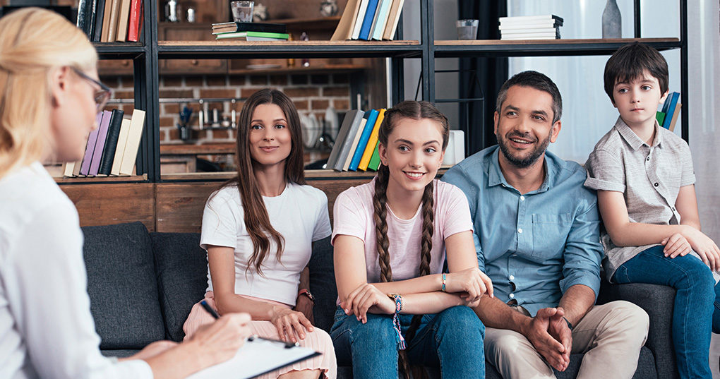 Mother, father, and daughter sitting in office.