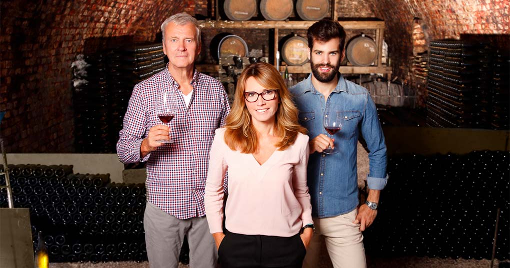 A group of people standing in a wine cellar