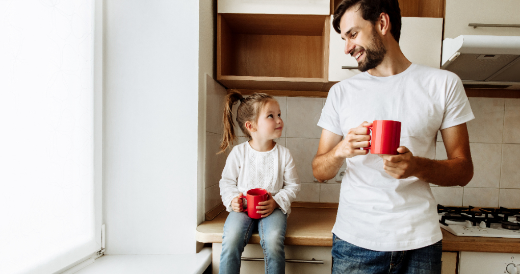 A father and young daughter with matching mugs